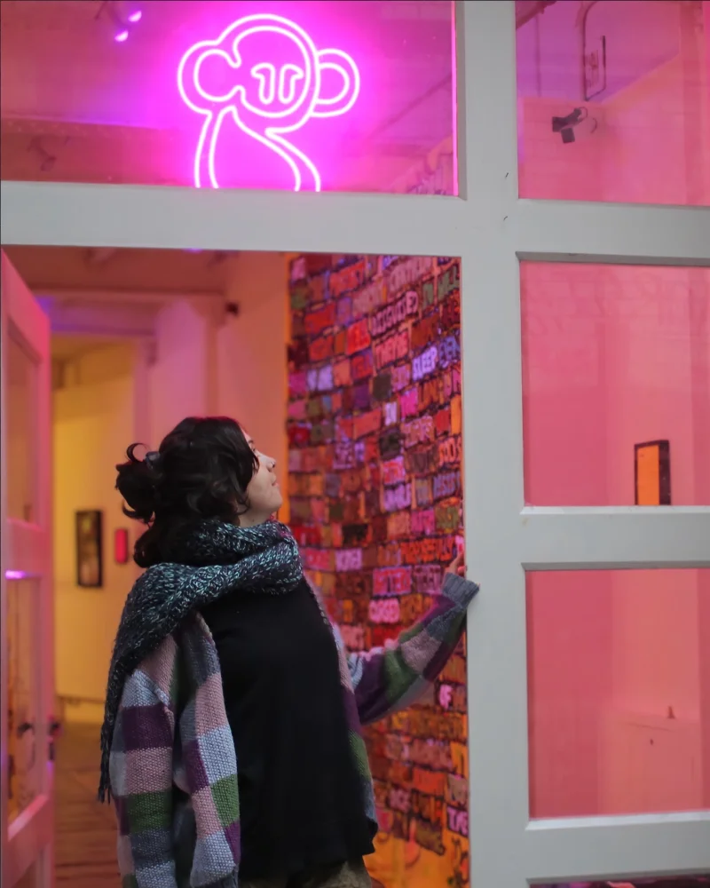 Kim stood in the doorway of CentreSpace gallery, Bristol with a pink neon sign above her.